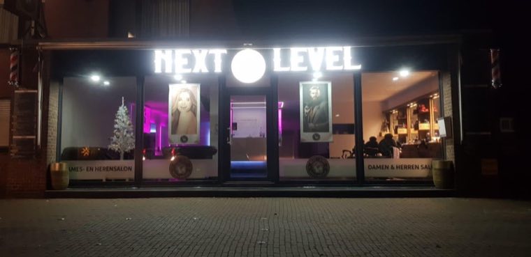 Next Level – Leuchtschrift Fassade bei Nacht