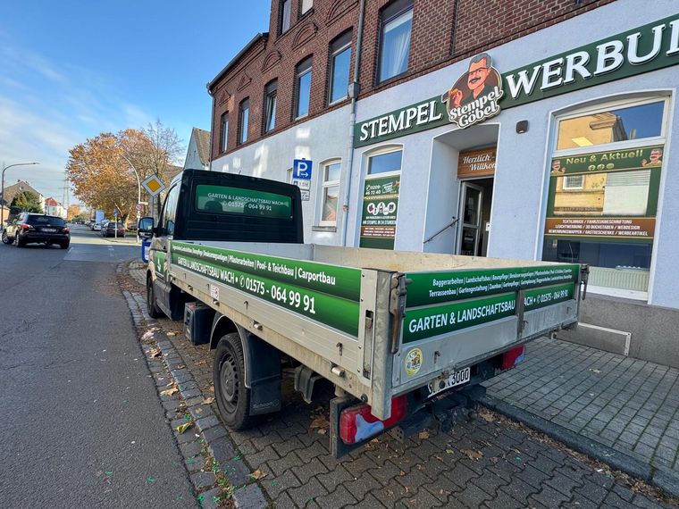 Garten- und Landschaftsbau Wach &ndash; Pritschenwagen vor unserem Ladenlokal