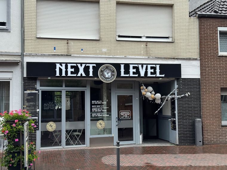 Next Level &ndash; Leuchtschriftzug über der Ladenfront